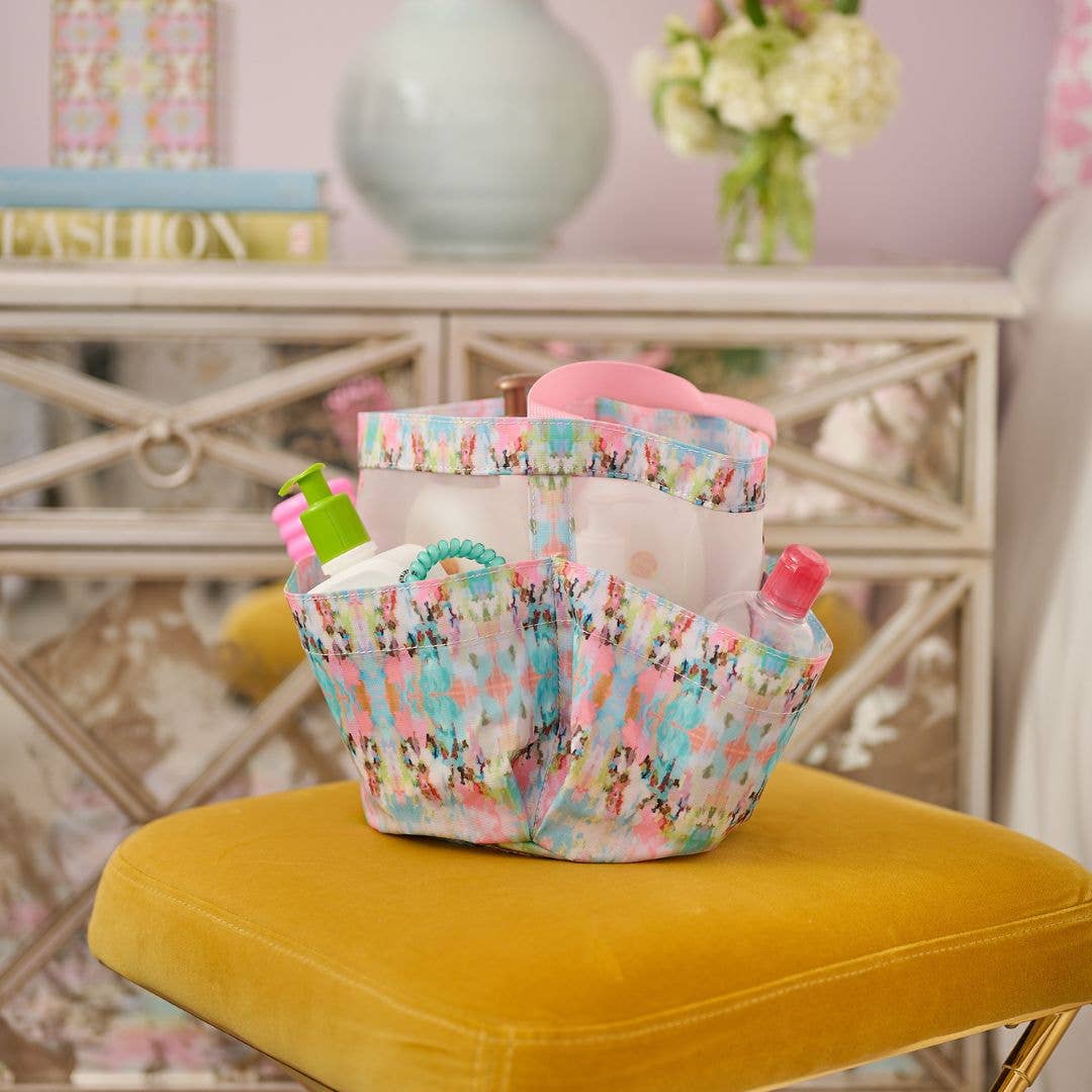 Colorful shower caddy with toiletries on a yellow chair in a blurred room setting
