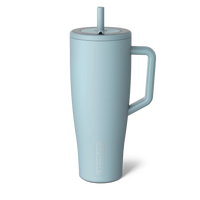 A light blue insulated travel tumbler with a matching handle, lid, and straw, shown on a clean white background. The brand name 'CUPPAK' is embossed vertically near the bottom.