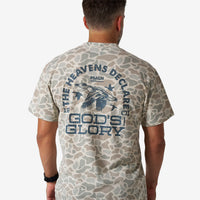 Man wearing a camouflage t-shirt with text and graphic design on the back