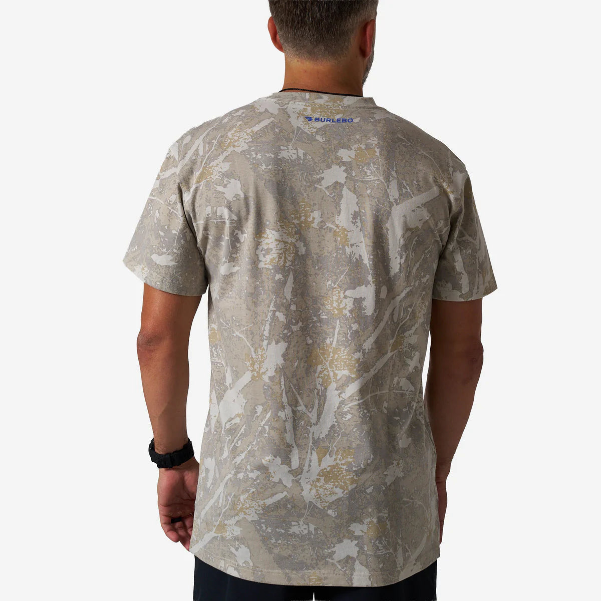 Person wearing a camouflage-patterned t-shirt on a white background