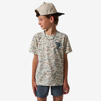 Child wearing a camouflage t-shirt with a logo and a cap on a white background