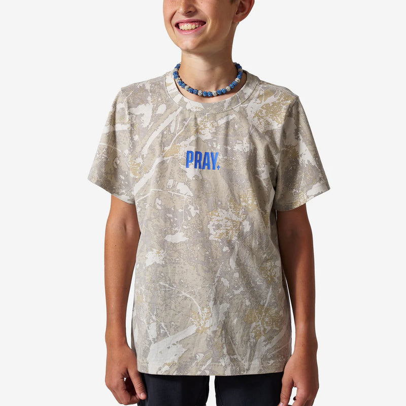 Person wearing a t-shirt with 'PRAY.' printed on it against a white background