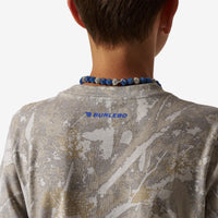 Person wearing a camouflage shirt with 'Burlesco' branding, focusing on the shirt and necklace.