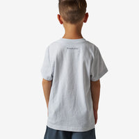 Child wearing a gray t-shirt with a brand logo on the back against a white background