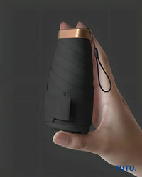 Hand holding a black folding knife with a brown handle against a dark background