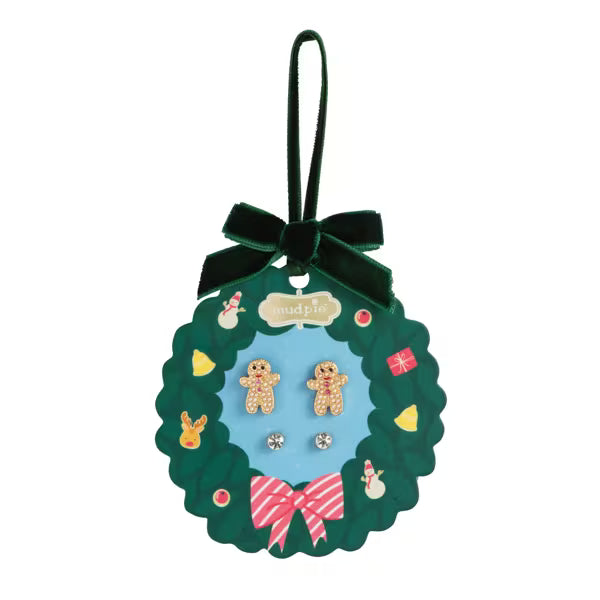 Set of earrings in a decorative green card holder with a bow on a white background