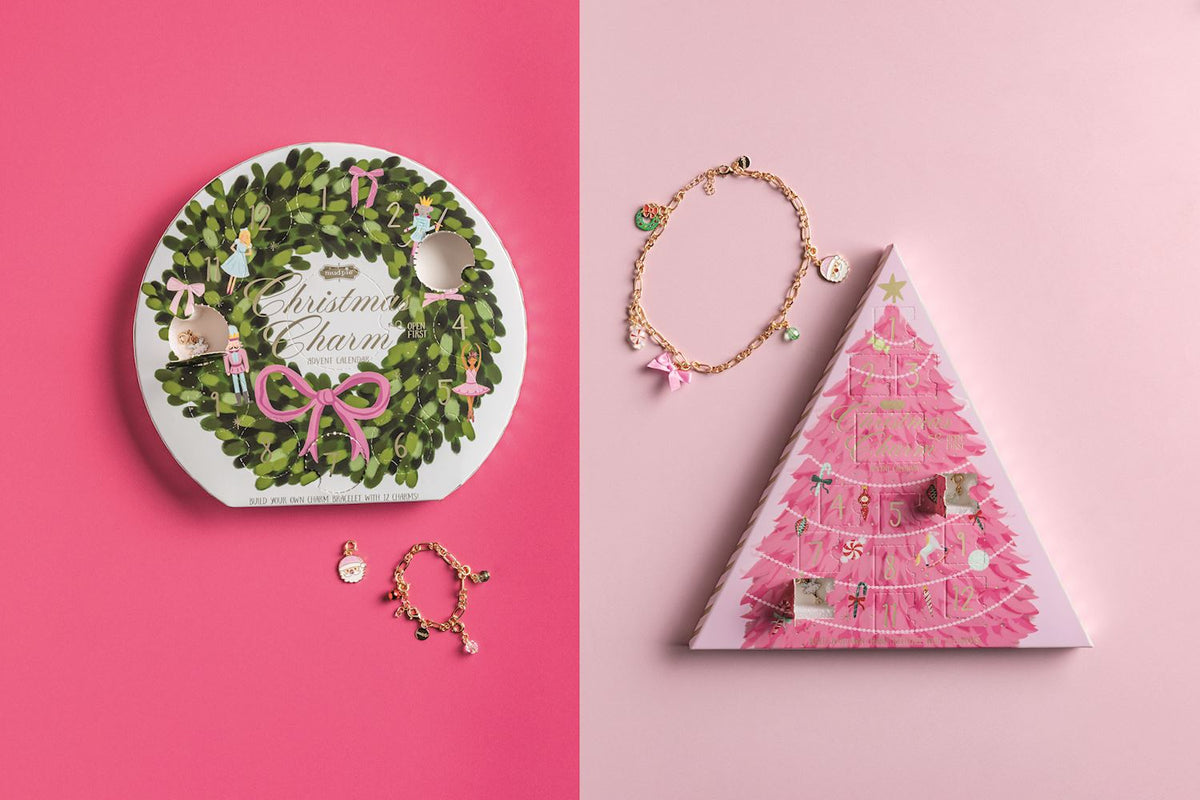 Christmas-themed jewelry and packaging on a pink background