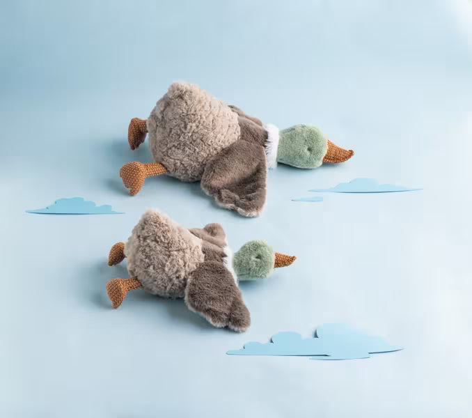 Two duck plushes on a light blue background 