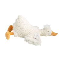 A plush stuffed duck toy in white textured fleece with orange feet and beak, lying on a plain white background. A small paper tag is attached to its side.