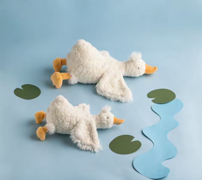 Two white fluffy stuffed goose plush toys on a blue background