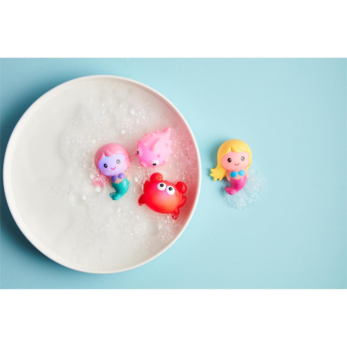 Colorful mermaid and crab figurines on a white plate with a blue background
