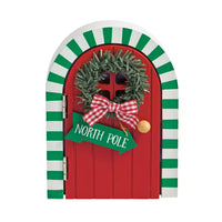 Red door with green wreath, bow, and 'North Pole' sign on a white background
