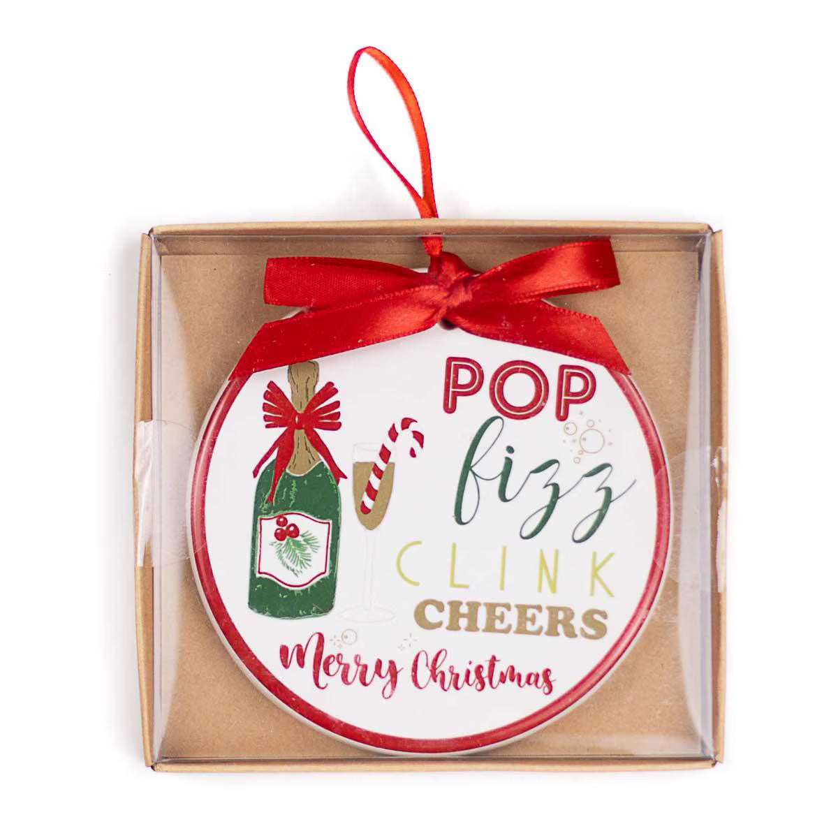 A round Christmas ornament in a clear square gift box with a kraft paper insert. The ornament is white with red and green text reading 'POP fizz CLINK CHEERS Merry Christmas' and features illustrations of a green champagne bottle, a candy cane, and a red ribbon bow.