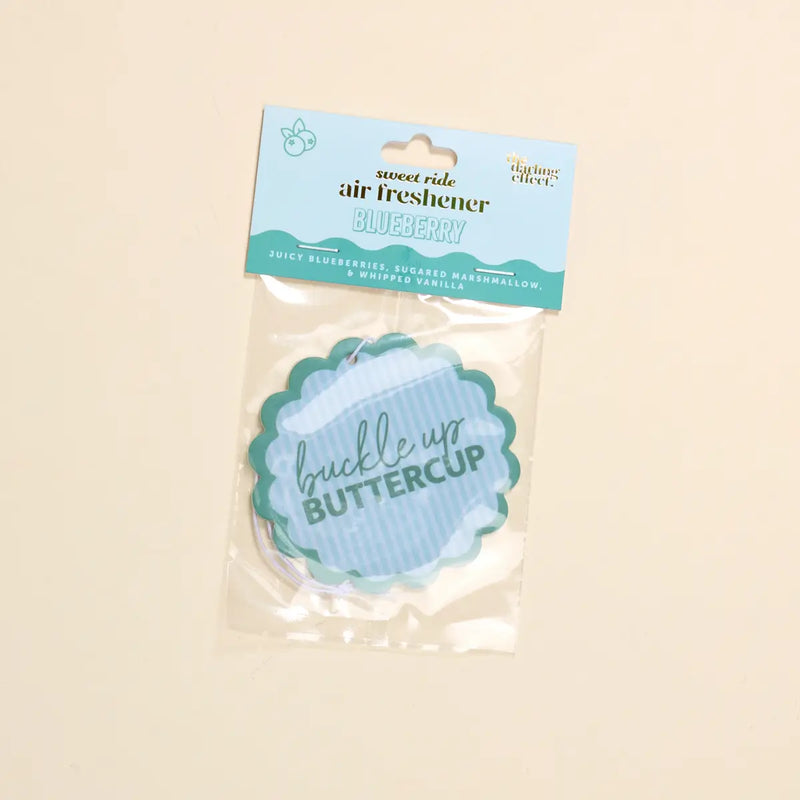 Package of a blueberry-scented air freshener with 'buckle up buttercup' text on a beige background