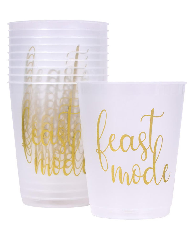 A stack of and a single translucent white plastic party cup with metallic gold foil script reading 'feast mode' on a white background.