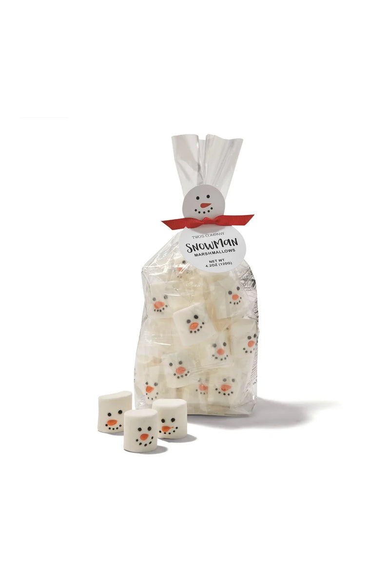 A clear plastic bag of marshmallows tied with a white bow and red ribbon, printed with snowman faces, with three small marshmallows placed in front on a white background.