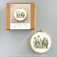 Embroidery kit with floral design and packaging on a gray background