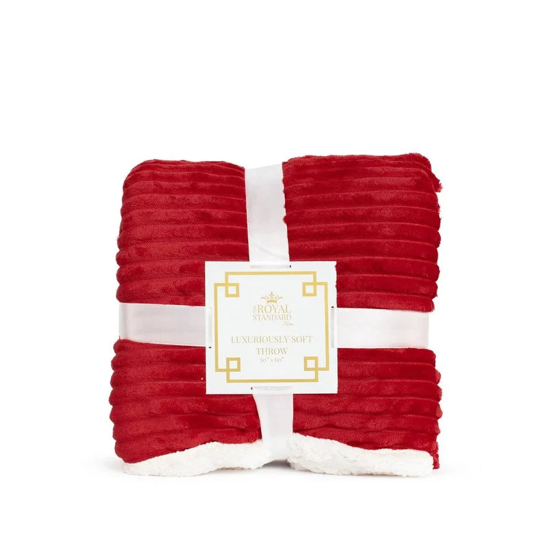 A folded red plush ribbed throw blanket with a white sherpa underside, wrapped in a white ribbon with a white paper label that reads Royal Standard.