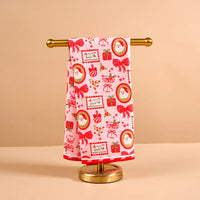 Decorative towel with Christmas patterns on a gold stand against a beige background
