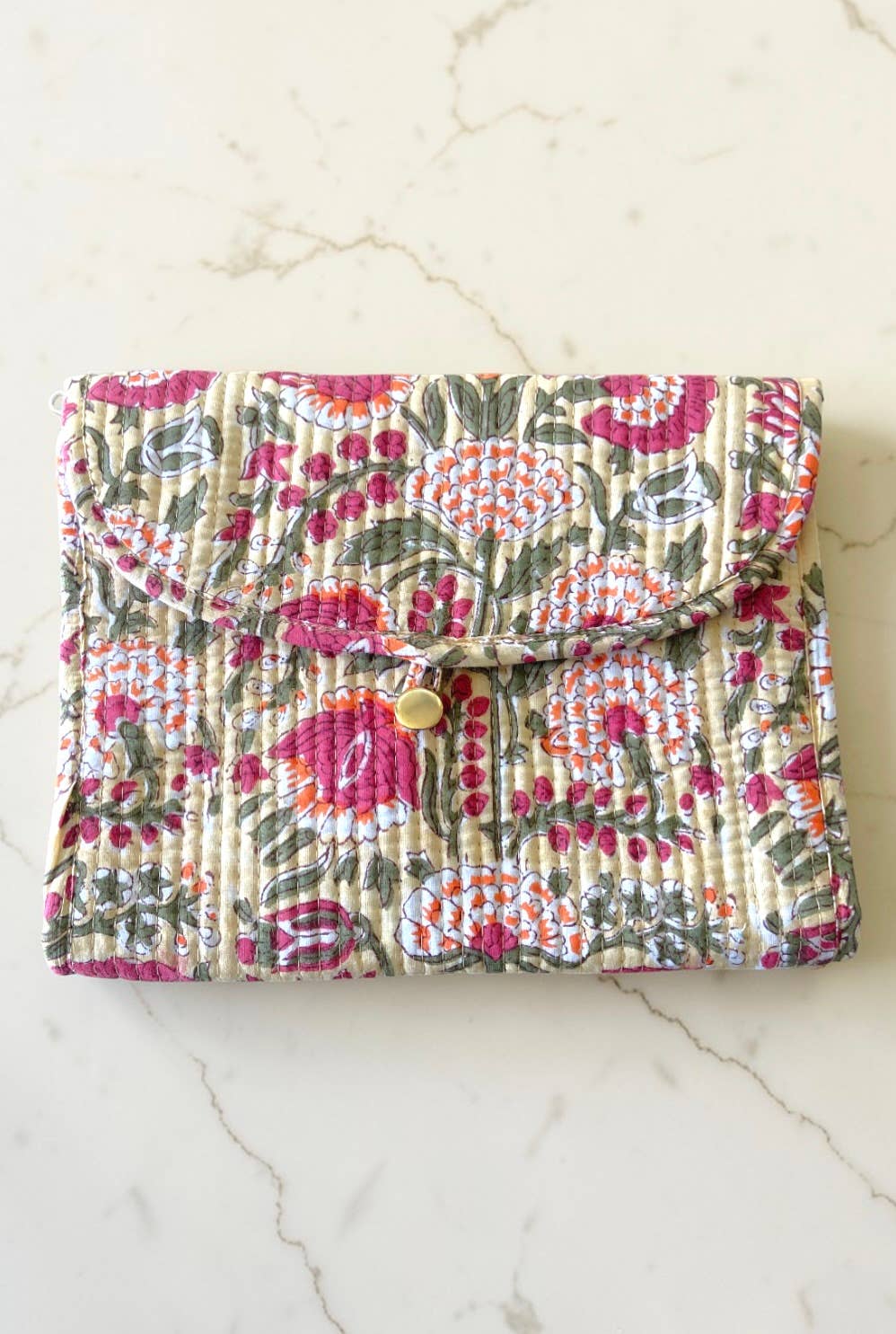 Floral patterned clutch bag on a marble surface