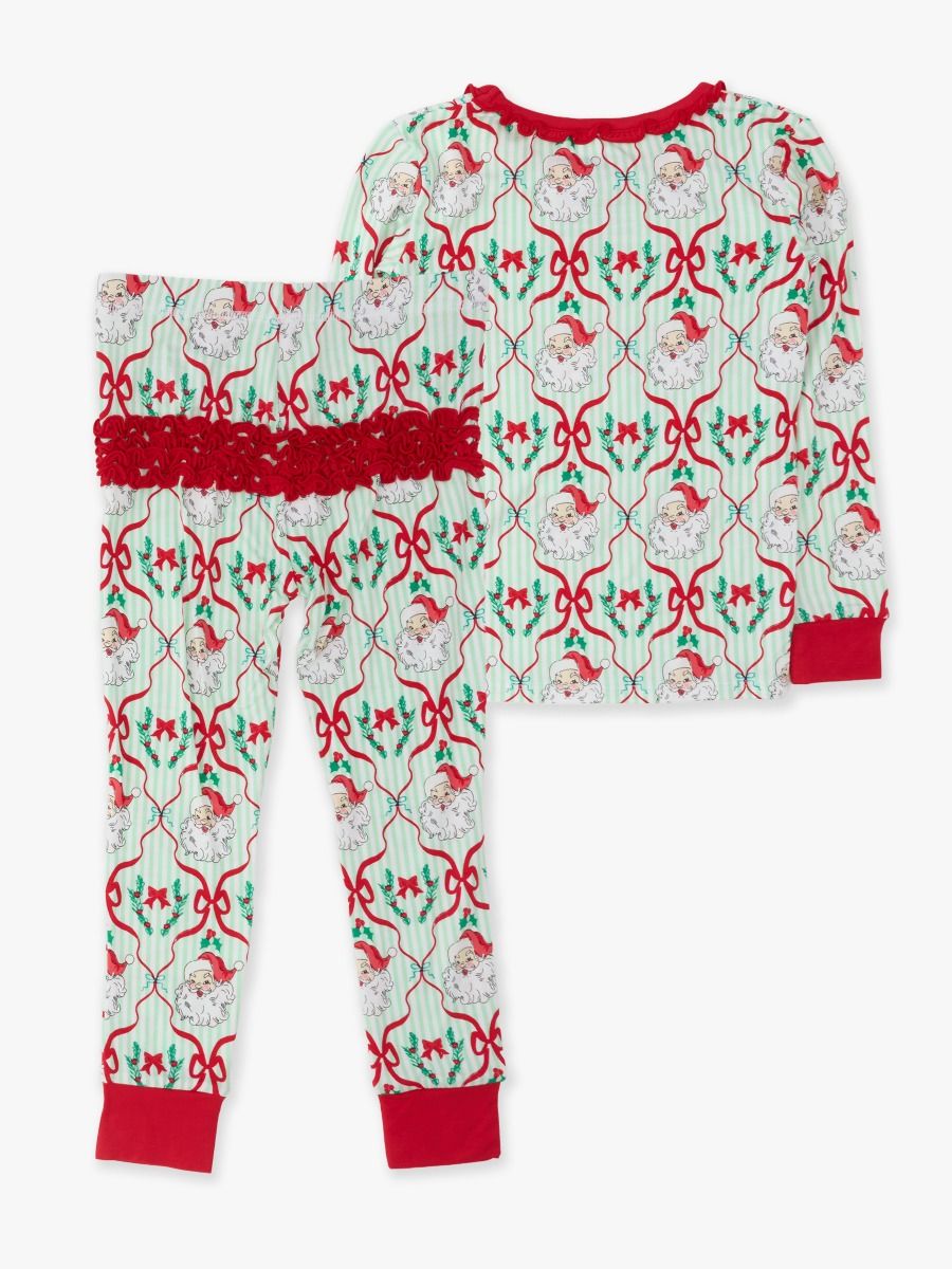 A two-piece Christmas pajama set featuring a long-sleeve top and matching pants. The pajamas have a festive pattern with Santa Claus, red bows, holly, and stars on a pale green and white background, with solid red ribbed trim at the collar, cuffs, and pocket openings.