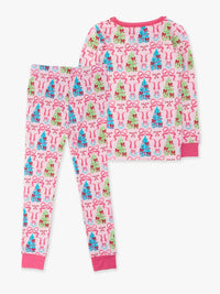 A two-piece children's pajama set featuring a long-sleeve top and matching pants with an all-over Christmas tree and bow pattern on a white background, finished with pink ribbed cuffs and collar.