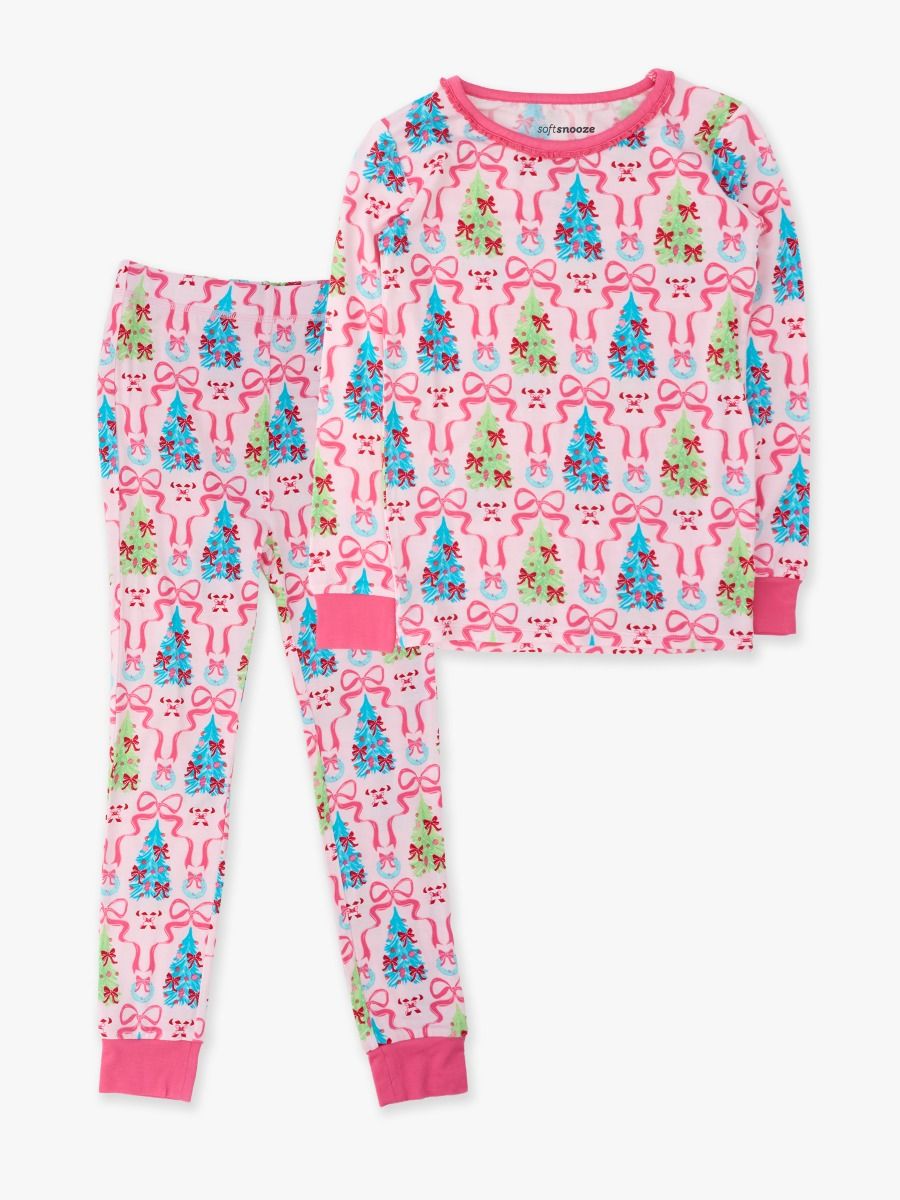 A two-piece children's pajama set featuring a long-sleeve top and matching pants with a festive holiday print of Christmas trees, bows, and snowman faces on a light pink background.