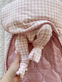 Pink checkered baby outfit with a textured pink blanket
