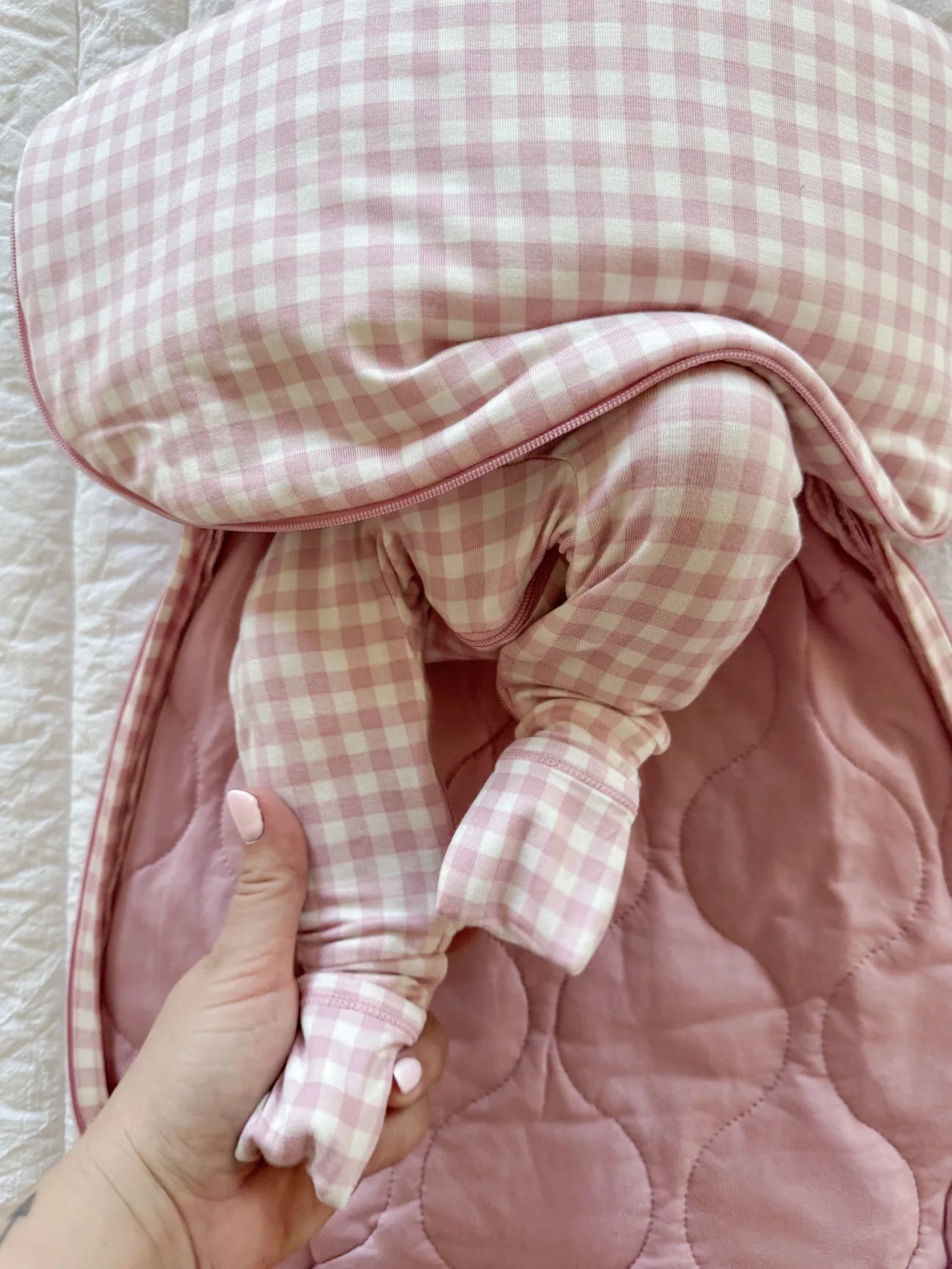 Pink checkered baby outfit with a textured pink blanket