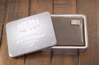 Brown leather wallet in a metal box with 'Zep-Pro' branding on a wooden surface