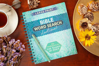 Bible Word Search Devotional book on a wooden table with flowers and a cup of tea.