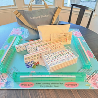 Mahjong game set on a table with a bag labeled 'Mahjong Studios' in the background.