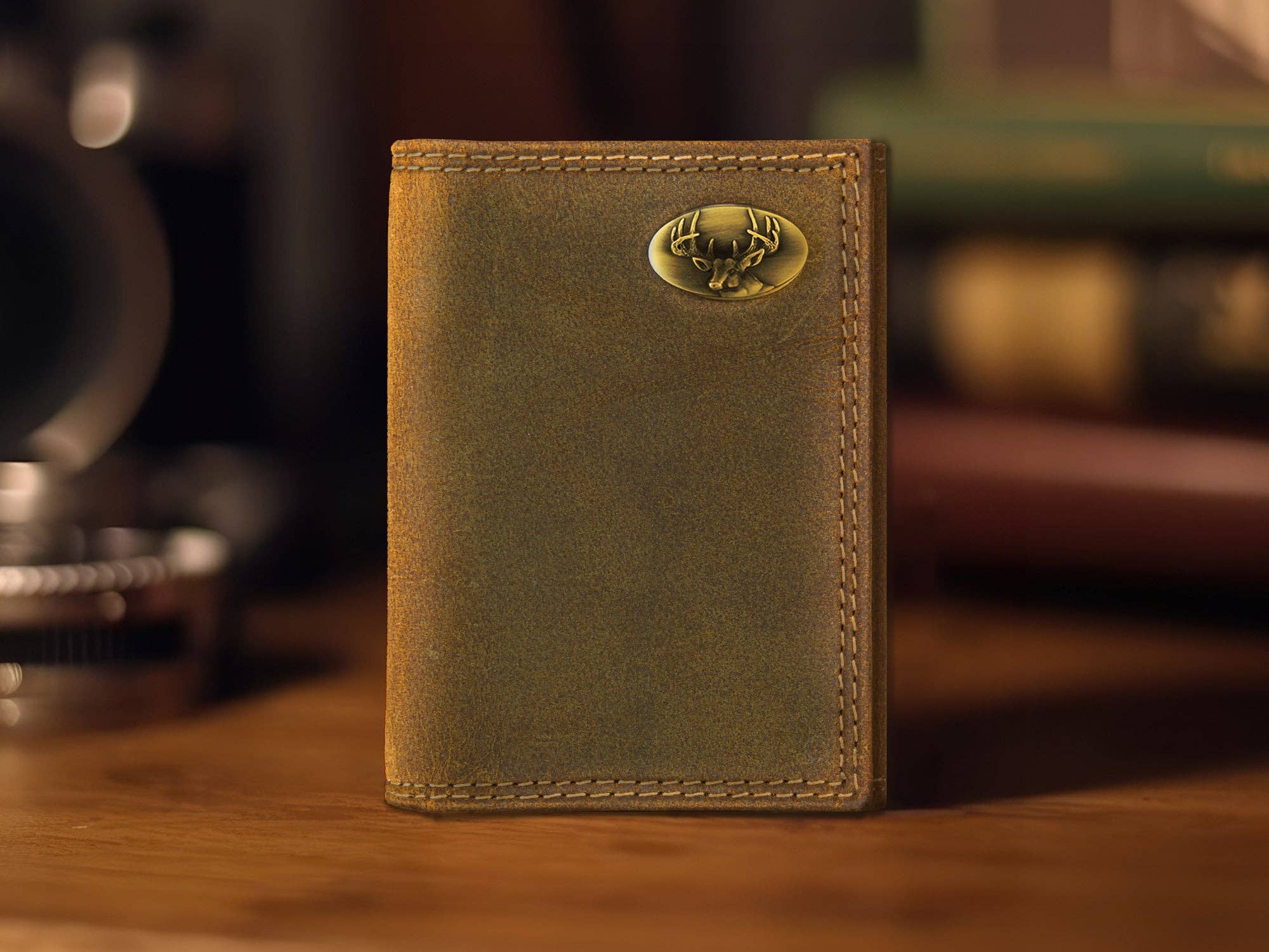Brown leather wallet with a gold emblem on a wooden surface