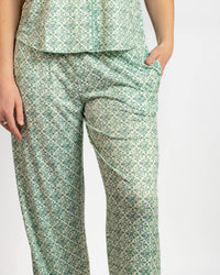 Green patterned pants worn by a person on a white background