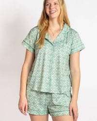 Woman wearing a green patterned pajama set on a white background