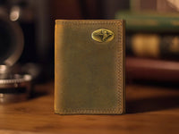Brown leather wallet with a gold emblem on a wooden surface