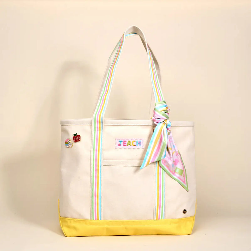Tote bag with colorful accents and 'TEACH' embroidery on a beige background
