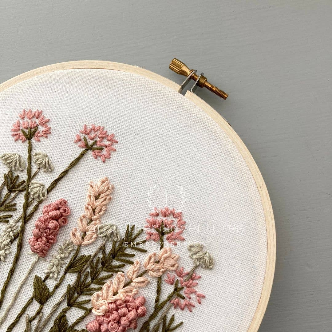 Embroidery hoop with floral embroidery on a gray background