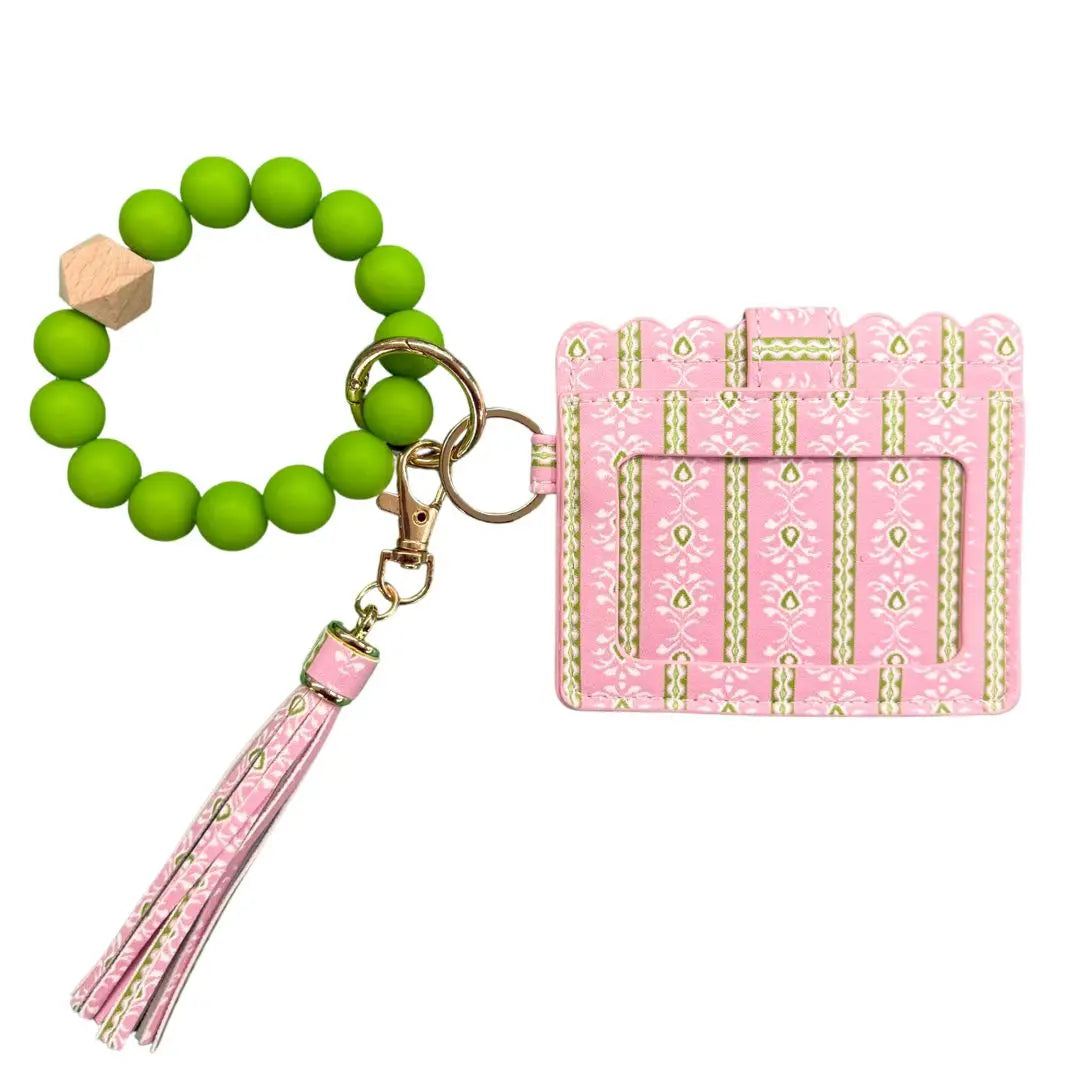 Pink gift box keychain with green beaded charm on a white background