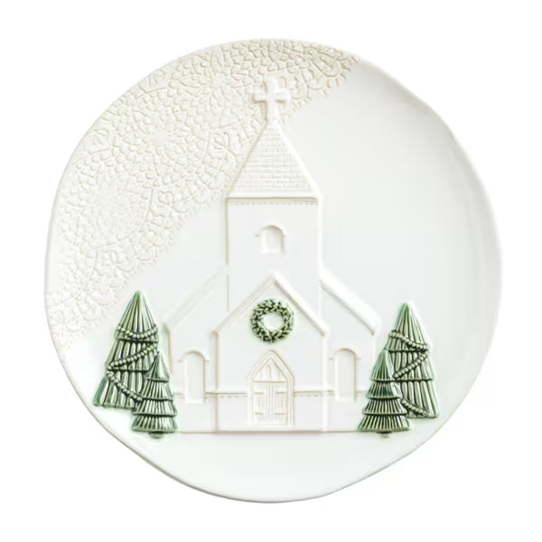 A white ceramic Christmas plate featuring an embossed church design with a green wreath and two green pine trees.