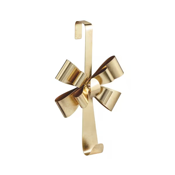 A polished gold metal hanging ornament shaped like a bow with a hook at the top, shown against a plain white background.
