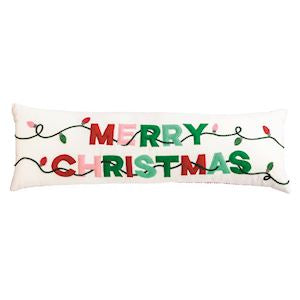 A rectangular white Christmas lumbar pillow featuring the words 'MERRY CHRISTMAS' in red and green letters, decorated with a green string light pattern and small red and green bulbs.