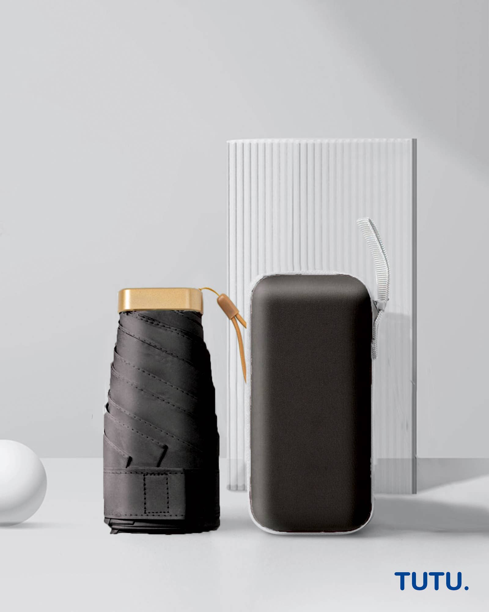 Collapsible umbrella and its carrying case on a light gray background with 'TUTU.' branding.