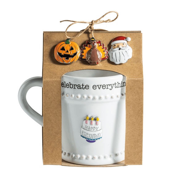 White mug with decorative text and charms in a gift box