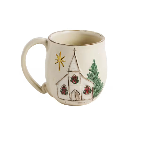 An off-white ceramic mug featuring a hand-painted illustration of a small church with red wreaths, a gold star, and a green pine tree on a white background.