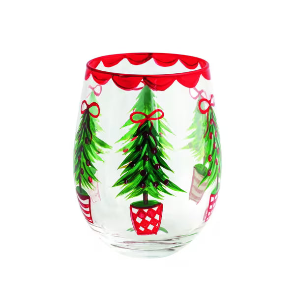 A clear stemless wine glass decorated with hand-painted green Christmas trees, red bows, and red scalloped trim at the rim, shown against a plain white background.
