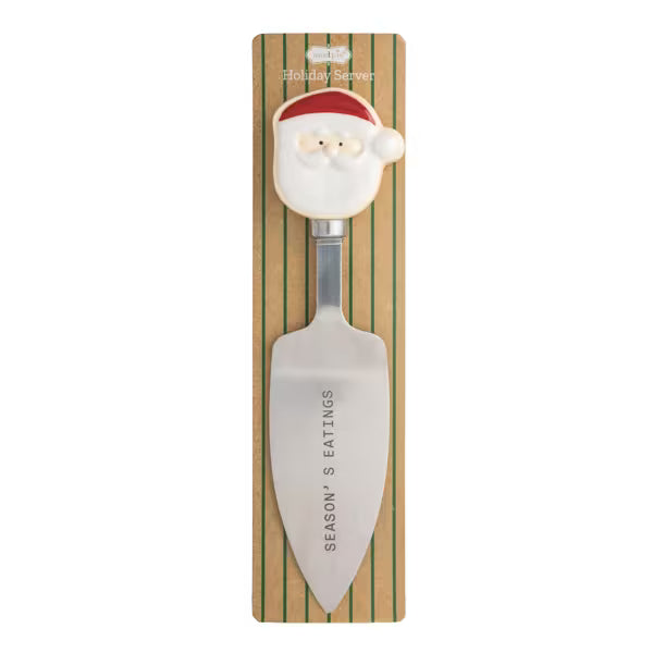 A festive holiday serving spatula with a Santa Claus head handle, mounted on a striped cardboard backing labeled 'Holiday Serving' and 'Season's Eatings'.