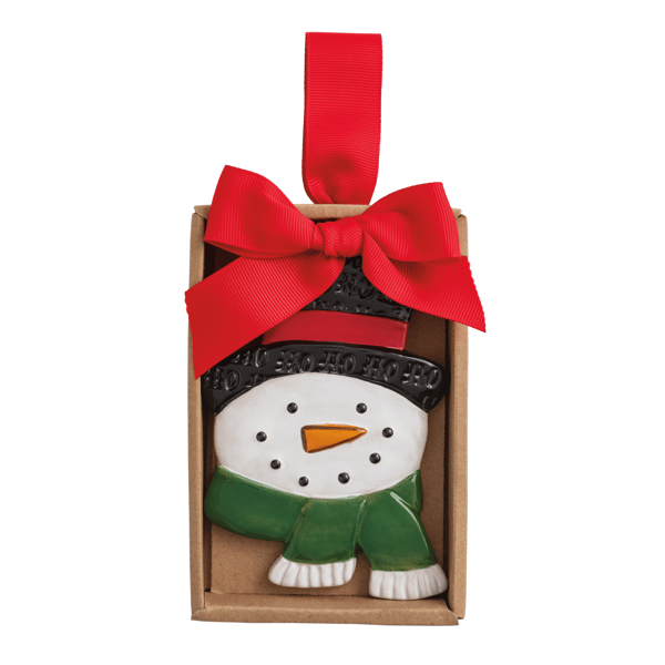 A ceramic snowman ornament displayed inside a brown gift box with a large red ribbon bow and hanging loop, on a plain white background.