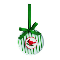 A round white Christmas ornament with green vertical stripes, a green ribbon bow, and a red cardinal bird illustration in the center, shown on a plain white background.