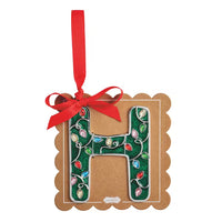 A decorative hanging ornament shaped like the letter H, made from brown kraft paper with a green holiday lights pattern and a red ribbon loop at the top, shown on a plain white background.